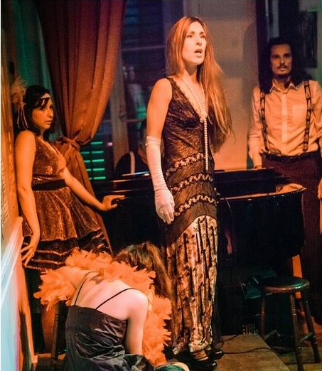 Elisabeth Theodorou singing in a beaded 1920s gown beside the piano in La Folle Joie
